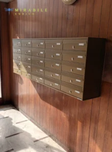 Una raccolta di immagini che mostrano diversi stili di cassette postali a muro, caratterizzate da vari materiali come legno e metallo, e design che vanno da scomparti opachi a quelli con frontali trasparenti.